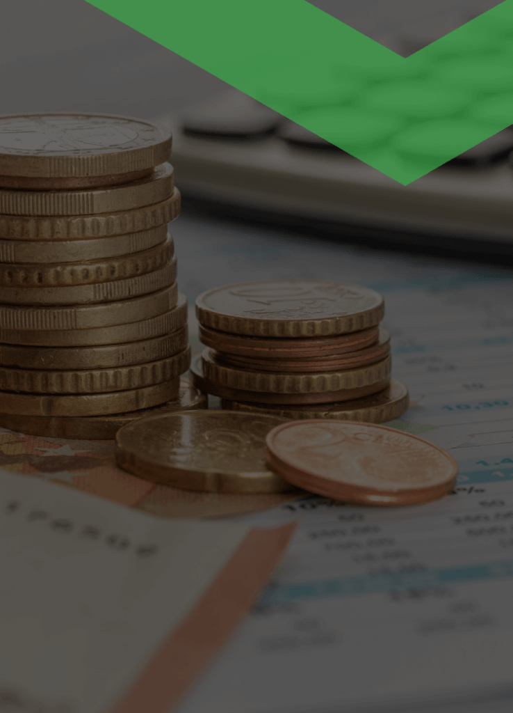 Gestapelte Euromünzen, ein Kugelschreiber und ein Taschenrechner liegen auf einem Finanzdokument mit Tabellen. Die Szene symbolisiert eine Sondertilgung – also eine außerplanmäßige Rückzahlung eines Teils eines Kredits.