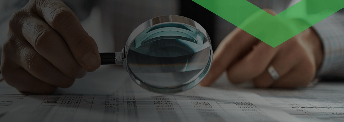 Eine Person mit Hemd und Krawatte hält eine Lupe über ein Zahlen- und Tabellenblatt auf einem Schreibtisch. Die Szene symbolisiert die sorgfältige Prüfung der Kreditwürdigkeit, also der finanziellen Zuverlässigkeit eines potenziellen Kreditnehmers.