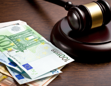 Ein Richterhammer liegt neben mehreren Euro-Geldscheinen auf einem dunklen Holztisch. Die Szene symbolisiert die rechtliche Regulierung von Geldgeschäften, etwa im Kontext des Kreditwesengesetzes (KWG), das den Rahmen für Banken und Kreditinstitute in Deutschland vorgibt.