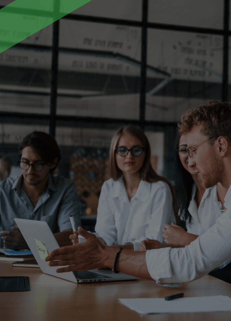 Eine Gruppe junger Menschen in Businesskleidung sitzt gemeinsam an einem Konferenztisch und diskutiert vor einem Laptop. Die Szene symbolisiert Entscheidungs- und Handlungsfähigkeit im geschäftlichen Kontext, etwa im Zusammenhang mit der rechtlichen Geschäftsfähigkeit.