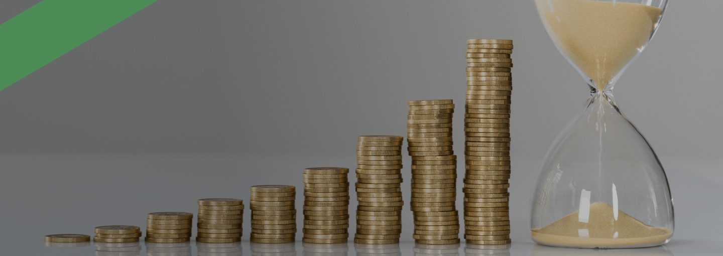 Mehrere Münzstapel sind in aufsteigender Höhe nebeneinander angeordnet, daneben steht eine Sanduhr mit ablaufendem Sand. Die Szene symbolisiert die Entwicklung von Rückzahlungen oder Vermögen über die Zeit hinweg, etwa im Zusammenhang mit der Kreditlaufzeit.