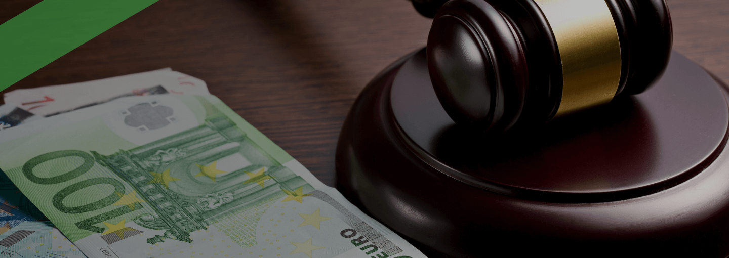 Ein Richterhammer liegt neben mehreren Euro-Geldscheinen auf einem dunklen Holztisch. Die Szene symbolisiert die rechtliche Regulierung von Geldgeschäften, etwa im Kontext des Kreditwesengesetzes (KWG), das den Rahmen für Banken und Kreditinstitute in Deutschland vorgibt.