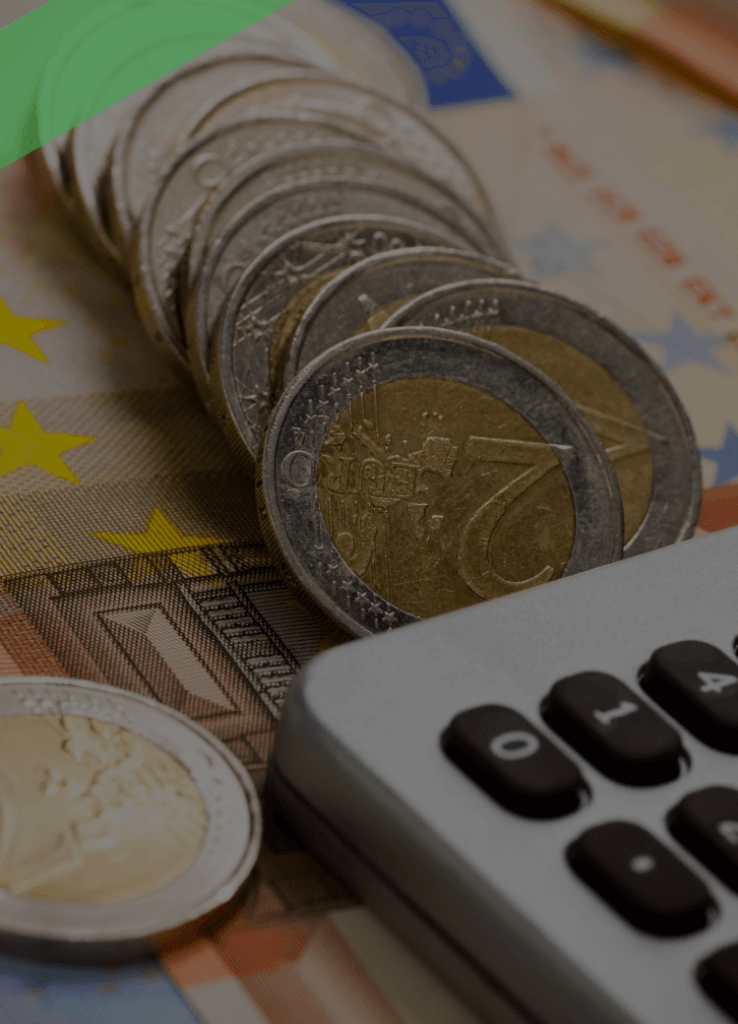 Mehrere gestapelte Euromünzen liegen auf Euro-Banknoten neben einem Taschenrechner. Die Szene symbolisiert finanzielle Kalkulationen im Zusammenhang mit kurzfristigen Krediten oder Liquiditätsengpässen.