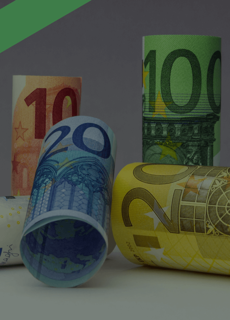 Verschiedenfarbige Euro-Geldscheine sind zu Rollen geformt und stehen oder liegen aufrecht nebeneinander. Die Szene symbolisiert den Roll-over-Kredit, bei dem ein Kreditbetrag regelmäßig verlängert und zu variablen Konditionen neu verzinst wird.