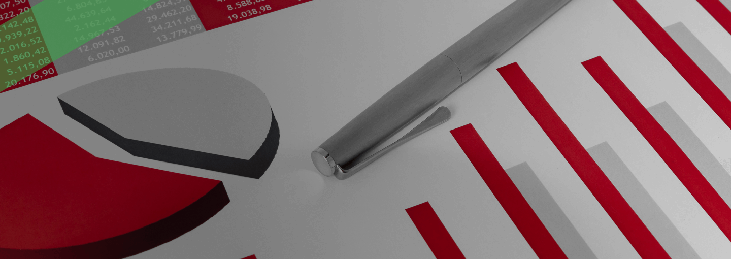 Ein Kugelschreiber liegt auf einem Finanzdokument mit roten und grauen Balken- und Kreisdiagrammen sowie einer Tabelle. Die Szene symbolisiert die Analyse betriebswirtschaftlicher Kennzahlen, insbesondere des Verschuldungsgrads eines Unternehmens.