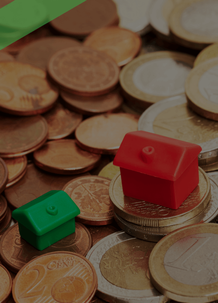 Zwei unterschiedlich große Spielzeughäuser stehen auf einem Haufen Euro-Münzen. Die Szene symbolisiert die Zinsspanne, also die Differenz zwischen Soll- und Habenzinsen bei der Kreditvergabe durch Banken.