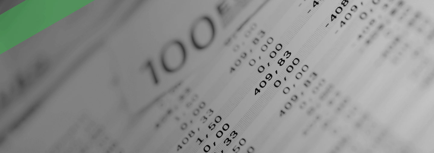 Nahaufnahme eines Kontoauszugs oder Abrechnungsdokuments, auf dem verschiedene Buchungen und Beträge zu sehen sind. Im Hintergrund ist ein 100-Euro-Schein erkennbar. Die Szene symbolisiert regelmäßige Zahlungsverpflichtungen, etwa die monatliche Kreditrate.