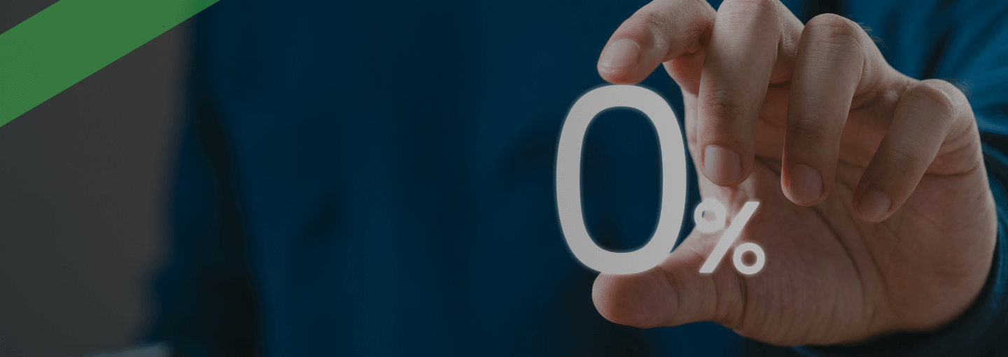 Eine Hand hält das Symbol „0 %“ in die Kamera. Der Hintergrund ist unscharf und dunkel gehalten. Die Szene symbolisiert eine Null-Prozent-Finanzierung, bei der für einen Kredit oder eine Finanzierung keine Zinsen anfallen.