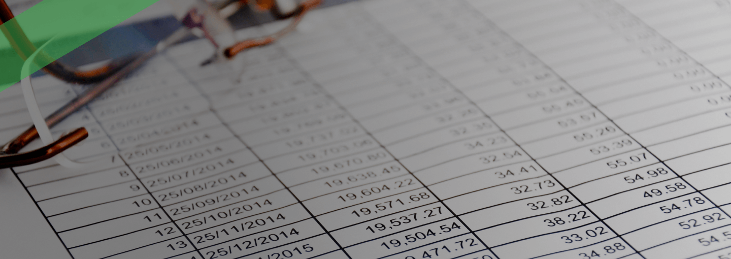 Nahaufnahme eines ausgedruckten Tabellenblatts mit Zahlen, Datumsangaben und Beträgen, das in einem Ordner abgeheftet ist. Die Szene symbolisiert einen Tilgungsplan, der die Rückzahlung eines Kredits über einen bestimmten Zeitraum hinweg detailliert darstellt.